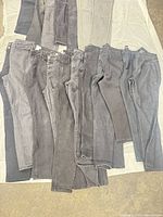 Array of black and grey jeans laid out on sheet