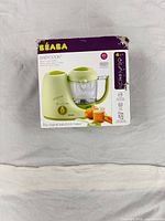 Damaged retail box for BEABA Babycook showing lime green appliance image and branding