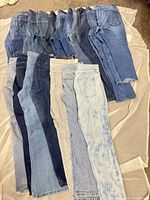 Eighteen pairs assorted women’s jeans in various washes laid out flat