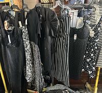 Group of dresses on hangers showing variety of styles (sequin, floral, striped, blazer, polka dot) and hangtags