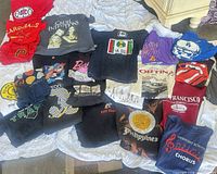 Spread of 25 assorted men’s graphic T-shirts laid out for overview