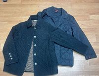 Both jackets laid flat showing fronts, collars, buttons, lining, quilting pattern