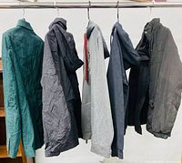 All five jackets on hanging rack displaying fronts, colours and styles