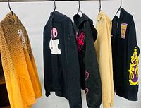 Five assorted women’s hoodies hanging on hangers