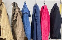 All six medium sweaters hanging on rack