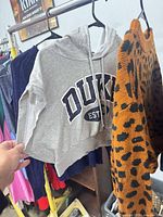 Grey Duke hoodie and leopard print sweater on rack
