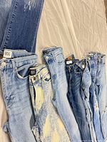 Seven jeans laid side by side to show overall quantity, washes and distressing