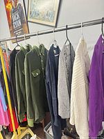 Rack showing six of the sweaters in assorted colors and styles