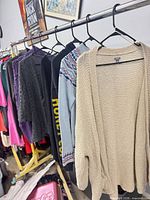 Rack showing all seven sweaters on hangers