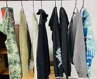 Eight assorted medium sweaters hanging on rack