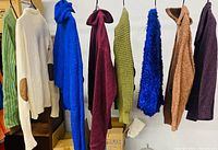 All eight sweaters hanging side by side showing colours, styles, and general condition