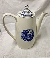 Full view of porcelain kettle showing handle, spout, lid and blue scene