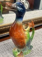 Front left view of multicolored duck-form pitcher