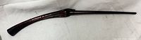 Full side view of curved dark brown wand