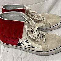 Left and right shoes profile showing red fringe and Snoopy graphic