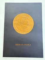 Front of black folder showing embossed gold Audubon seal