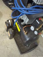 Full view of compressor, hose, oil bottles