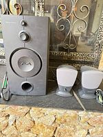 subwoofer and two satellite speakers on surface