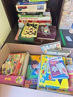 Cardboard box with multiple board games, puzzles and toys