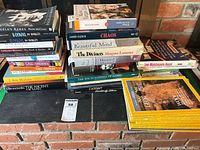 Stacked books showing titles such as Chaos, A Beautiful Mind, The Diviners and National Geographic magazines