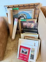 Group view of framed prints, rolled posters, and loose matted prints