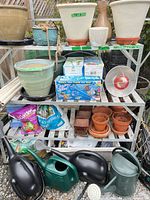 Shelving rack with pots, watering cans, soil bag, Aqua Globes boxes, hoses