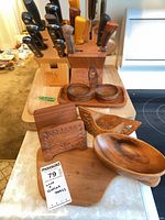 Knives in two blocks, cutting boards and wood serve pieces grouped on counter