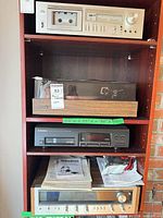 All four stereo components stacked on shelving plus manuals visible