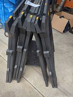 Four folded Stanley plastic sawhorses standing upright
