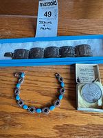 Overall lot showing both bracelets, medal, and box