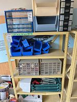 Shelf with two small-parts organizers and multiple blue bins