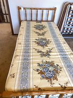 Top view of assembled twin bed showing floral mattress and spindle headboard