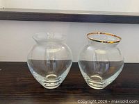 Front view of both clear glass bulb vases showing shape and gold rim detail on one