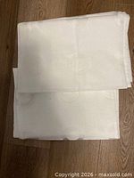 Stacked white fabric pieces folded