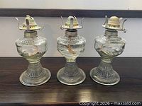 Front view of all three matching glass oil lamps
