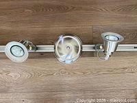 Central canopy and two adjacent lamp heads on rail