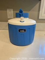 Front view of blue Thermos jug with lid, spout and handle