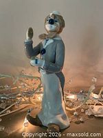 Left-front view of porcelain clown figurine with decorative lights