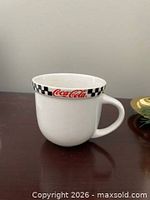 Full view of mug showing checkerboard rim and logo