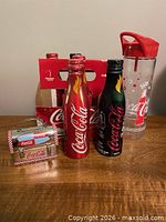 Group view of five aluminum bottles, reusable bottle, and mini tin