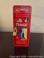Front view of Coca-Cola locker tin with padlock