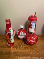 Group shot showing aluminum bottle, three round PET bottles, and reusable straw bottle
