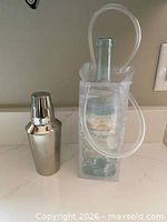 Shaker standing beside clear gel cooler bag with display bottle inside