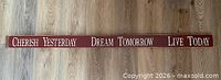 Full view of long burgundy pine sign with inspirational quote text
