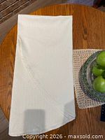 Folded ivory tablecloth on wooden table showing overall color and scale