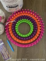Top view of stacked bright colour looms with yarn cake and tools visible
