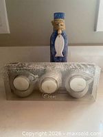 Full lot showing sealed candle holder set in front of blue bottle vase