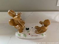 Oblique view showing two gingerbread figures on snowy base