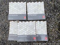 Four sealed Novecento tile sheets on gravel surface