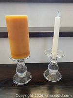Two glass candle holders shown with pillar and taper candles to illustrate dual use